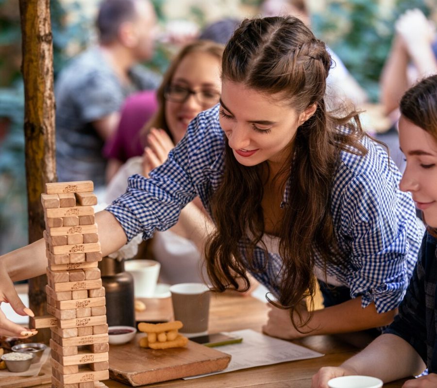 playing-jenga-game-restaurant-with-best-friends-eating-tasty-snacks_8353-10618